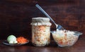 Homemade sauerkraut with carrots in a glass jar and bowl on a dark wooden background. Fermented food. Marinated vegetables Royalty Free Stock Photo