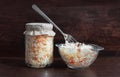 Homemade sauerkraut with carrots in a glass jar and bowl on a dark wooden background. Fermented food. Marinated vegetables Royalty Free Stock Photo