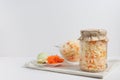 Homemade sauerkraut with carrots in a glass jar and bowl on a white wooden background. Fermented food. Copy space Royalty Free Stock Photo