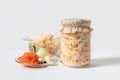 Homemade sauerkraut with carrots in a glass jar and bowl on a white wooden background. Fermented food Royalty Free Stock Photo