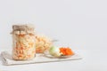 Homemade sauerkraut with carrots in a glass jar and bowl on a white wooden background. Fermented food Royalty Free Stock Photo