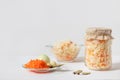 Homemade sauerkraut with carrots in a glass jar and bowl on a white wooden background. Fermented food Royalty Free Stock Photo