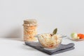 Homemade sauerkraut with carrots in a glass jar and bowl on a white wooden background. Fermented food Royalty Free Stock Photo
