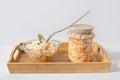 Homemade sauerkraut. Fermented food. Sauerkraut with carrots in a glass jar and bowl in a wooden tray on a white background Royalty Free Stock Photo