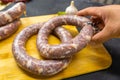 Homemade sausage, a man`s hand in the frame