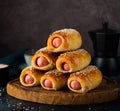 Homemade sausages in dough pigs in blanket on a wooden board, dark background Royalty Free Stock Photo