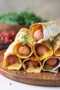 Homemade sausages in dough with sesame served with tomato sauce, light stone background. Pigs in blanket. Fast food