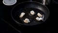 Homemade sauteed chicken breast in a frying pan. Art. Close up of turning chopped chicken breast in flour at the kitchen Royalty Free Stock Photo