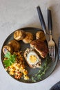Homemade scotch eggs on a plate served with bulgur pilaf, grilled mushroom and aromatic herbs. Meat cutlet with boiled egg. Royalty Free Stock Photo