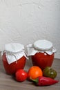 Homemade seasonal preparations. In glass jars, tomato paste. The neck of the cans is wrapped in paper and tied with rope. Nearby