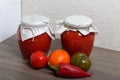 Homemade seasonal preparations. In glass jars, tomato paste. The neck of the cans is wrapped in paper and tied with rope. Nearby