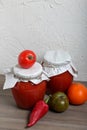 Homemade seasonal preparations. In glass jars, tomato paste. The neck of the cans is wrapped in paper and tied with rope. Nearby