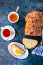 Homemade sesame seed Challah bread and tea on a blue stone background.