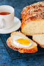 Homemade sesame seed Challah bread and tea on a blue stone background.