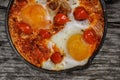 Homemade Shakshuka served in a Frying Pan. Eggs Poached in Spicy Tomato Pepper Sauce.