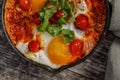 Homemade Shakshuka served in a Frying Pan. Eggs Poached in Spicy Tomato Pepper Sauce.
