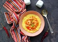 Homemade shrimp and grits with smoked sausages sweet red peppers onions and cheese in a pink bowl on a dark concrete background Royalty Free Stock Photo
