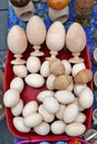 Homemade simple rustic wooden Easter eggs lie in a red plastic basket