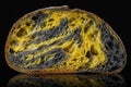 Homemade Slice of sourdough freshly baked bread on black background, activated carbon, pumpkin and curcuma spice