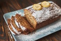 Homemade sliced banana cake decorated with sugar powder and three banana Royalty Free Stock Photo