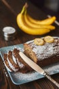 Homemade sliced banana cake decorated with sugar powder and three banana Royalty Free Stock Photo