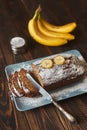 Homemade sliced banana cake decorated with sugar powder and three banana Royalty Free Stock Photo