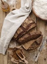 Homemade sliced round rye bread on a wooden table with malt and