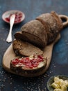 Homemade sliced rye bread on a wooden table and a sandwich with