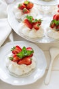 Homemade small strawberry pavlova meringue cakes with mascarpone cream and fresh mint leaves Royalty Free Stock Photo