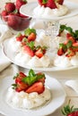 Homemade small strawberry pavlova meringue cakes with mascarpone cream and fresh mint leaves Royalty Free Stock Photo