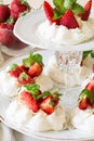 Homemade small strawberry pavlova meringue cakes with mascarpone cream and fresh mint leaves Royalty Free Stock Photo