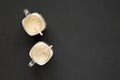 Homemade smoothie with coffee, oat and banana in glass jar mugs on a black background, top view. Overhead, from above, flat lay. Royalty Free Stock Photo