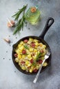 Homemade snacks on a stone or slate background. Warm salad with potatoes and smoked sausages. Flat lay. Royalty Free Stock Photo