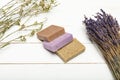 Homemade soap pile with dried lavender bunch on wooden surface Royalty Free Stock Photo