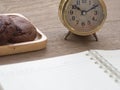 Homemade soft dark chocolate brownie cookies placed on a wooden plate on wooden table. Behind cookies have gold vintage alarm cloc