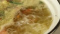 Homemade soup boils in a pan on the stove, preparing soup, dietary soup