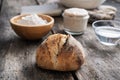 Homemade sourdough bread bun next to ingredients - flour, water and starter yeast Royalty Free Stock Photo