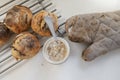 Homemade sourdough bread buns cooling on a rake next to a new starter yeast being made