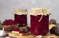 Homemade spicy caviar from beets, carrots, onions and garlic in two jars and bowl on gray table Royalty Free Stock Photo