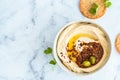 Homemade spicy hummus with tahini and olive oil in bowl, white marble background. Israeli traditional food Royalty Free Stock Photo