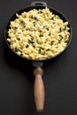 Homemade Spinach Mac and Cheese in a cast-iron pan on a black background, side view Royalty Free Stock Photo