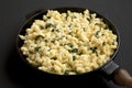 Homemade Spinach Mac and Cheese in a cast-iron pan on a black background, side view. Close-up Royalty Free Stock Photo