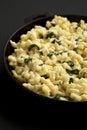 Homemade Spinach Mac and Cheese in a cast-iron pan on a black surface, side view. Close-up Royalty Free Stock Photo