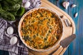 Homemade spinach pie quiche lorraine with eggs on wooden board top view