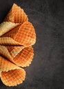 Homemade stacked empty cornets or ice cream waffle cones on dark background