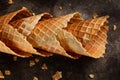 Homemade stacked empty cornets or ice cream waffle cones on dark background