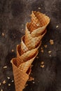 Homemade stacked empty cornets or ice cream waffle cones on dark background