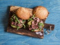 Homemade steak burger on wooden cutting board Royalty Free Stock Photo