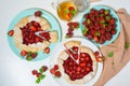 Homemade strawberry Biscuit with fresh ripe strawberries on blue and white plates with tea on a light background, top view