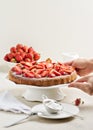 Homemade strawberry cake on a white cake stand.